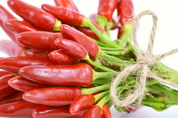 colorful of red chili peppers group  Tied with hemp rope on white background.
The pepper heat helps to stimulate secretions  clearing your nose,  antibacterial.