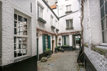 Old brick walls of cozy city mansion inside narrow streets with cobbled stones