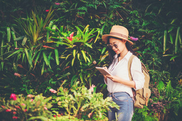 girl play the tablet  tourist travel in flower garden, Travel concept.