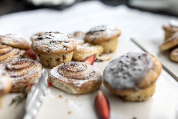 A delicious, freshly baked chocolate chip muffin and pastries frosted or spinkled with icing sugar on a business breakfast buffet