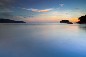 Sea at sunset.Seascape of smooth blurred blue sea water and small island at sunset with twilight sky and cloud  long exposure photograph.