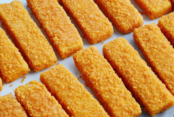 frozen fish sticks in Tray for oven on wooden background.
convenience food.