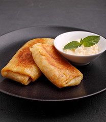 Close up of rolled pancakes with meet and sauce