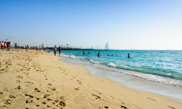Dubai, United Arab Emirates, April 20, 2018: Kite beach in Dubai with many visitors and Burj Al Arab hotel in the background