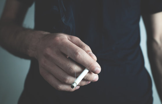 Caucasian man holding cigarette. Smoking concept