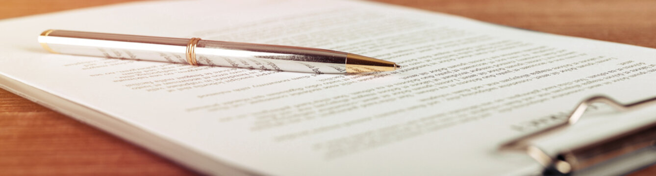 Pen lying on a contract or application form, wide angle view.