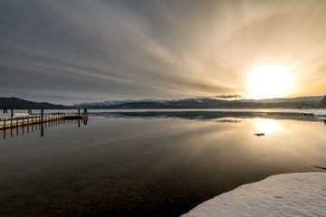 Dramatic sunrise on a popular Idaho mountain lake with a boat dock reflection
