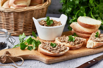 Chicken liver pate with bread on a wooden board