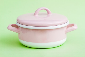 Vintage Style Pink Enamel Saucepan on Green Background