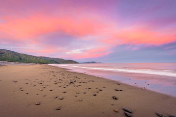 Rarangi Beach, Blenheim, Marlborough, New Zealand: Magical colorful sunset countryside with sandy beach on south island and purple pink cloudy sky and the mountain range of world famous wine region