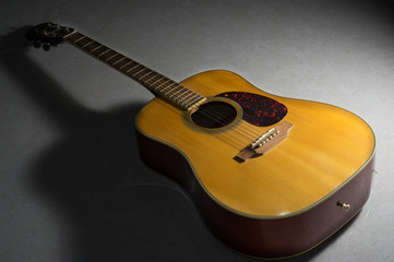 Obraz premium Wooden acoustic guitar on floor.