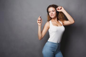 Fototapeta premium Woman listen to music in earphones, studio shot