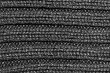 Texture of knitted fabric. Stranded threads. Cloth of warm winter clothes. Warm blanket. The texture of the blue gray and black threads. Background.