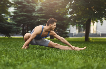 Obraz na płótnie Canvas Fitness man at stretching training outdoors