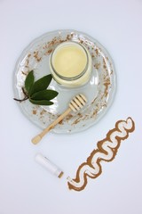Home made lip balm with beeswax, cocoa and sage. White background