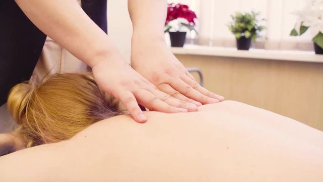 Top view. Close up hands of professional massage therapist doing massage of the woman's back