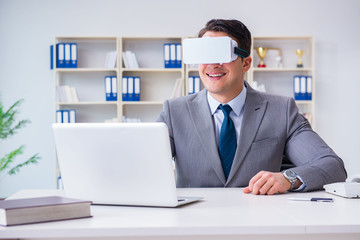 Businessman with virtual reality glasses in modern technology co