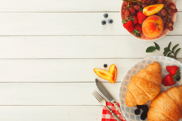 Naklejka na ściany i meble Continental breakfast with croissants and berries on white wood