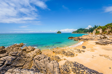 Abel Tasman National Park, New Zealand: Magical sandy beach with turquoise blue water on beautiful sunny summer day, enjoy breathtaking landscape by exploring the Splitt Apple ocean coast by kayaking