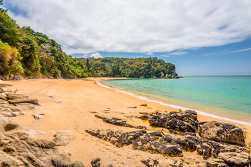 Abel Tasman National Park, New Zealand: Magical sandy beach with turquoise blue water on beautiful...