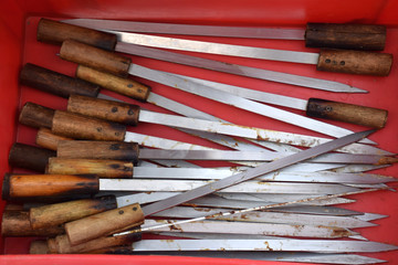 Fototapeta premium metal skewers with wooden handle in a red box after the barbecue 