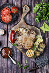 Grilled T-bone steak seasoned with spices and fresh herbs