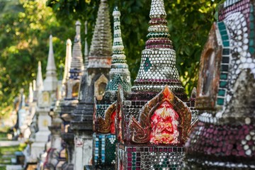 Row of buddhist temple mini stupas of different designs in the island of Koh Phangan, Thailand