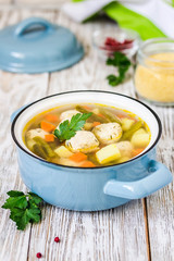 Slow cooker meatball soup in a pot on white wooden background. Top view, space for text.