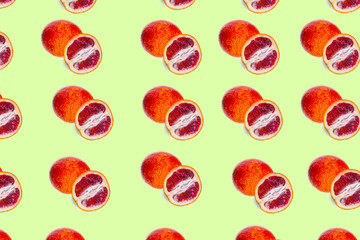 Food pattern of fruit red orange and half cut on colored background

