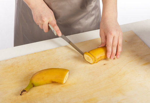 The girl cook cuts banana
