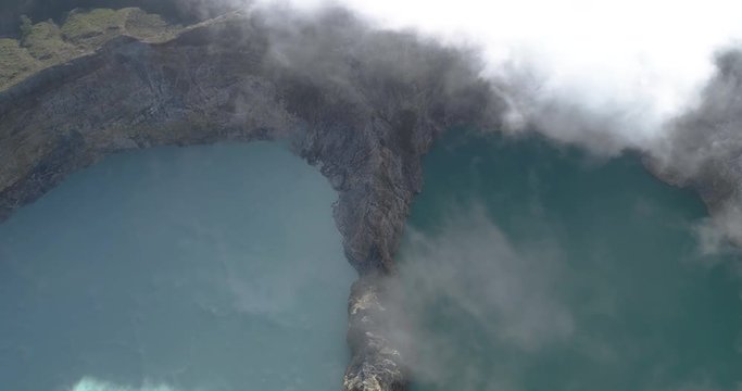 Kelimutu tri coloured volcano crater covered with mist an aerial view early morning, Indonesia