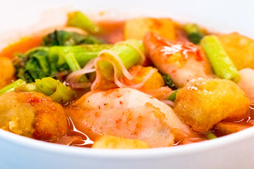 Thai food.Pink seafood flat noodles.Spicy lemongrass flavored soup with pork, chicken on white background.Close up