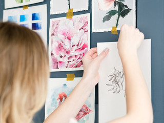 creative leisure. painting hobby. artful personality. talented girl sticking her watercolor drawings to the wall