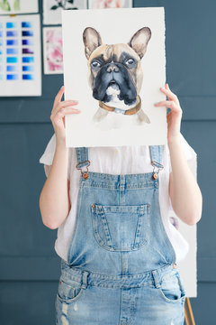 creative art lifestyle. drawing hobby and self expression. painter holding a watercolor drawing of french bulldog dog
