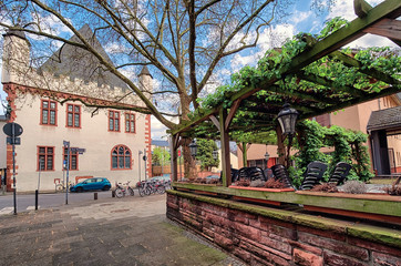 Beautiful view of street with historic traditional houses and cobbled street in Frankfurt, Germany with blue sky and clouds in spring
