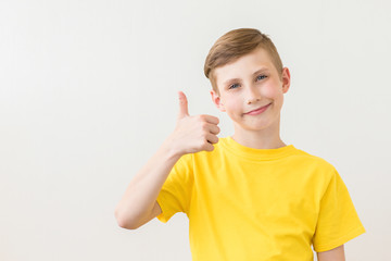 Young fresh teenager is posing with a thumb up sign