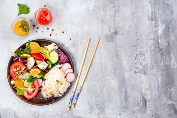 Spicy glass Rice noodles and vegetables salad on stone background