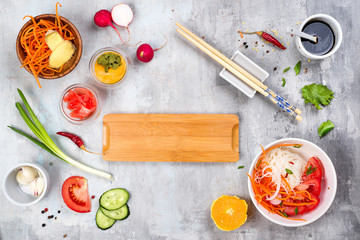 Asian rice noodles with vegetables and vegetarian salad on a plate on stone background