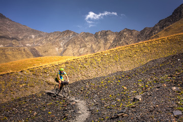 Fototapeta na wymiar Mountain biker is travelling in the highlands of Tusheti region, Georgia