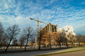 Fototapeta na wymiar construction site with crane blue sky with white clouds on background. copy space