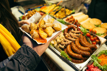 man hold plate with potatoes on street food festival