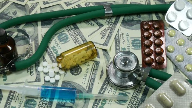 tablets and syringe with dollars and moving camera