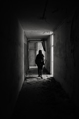 Silhouette of a woman in an abandoned devastated hotel