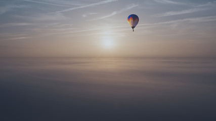 Heavenly View of Hot Air Balloon Rising Above Morning Clouds