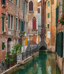 Fototapeta na wymiar Narrow canal with restaurant in Venice, Italy