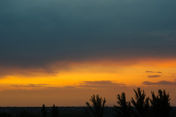 Landscape with dramatic light - beautiful golden sunset with saturated sky and clouds.