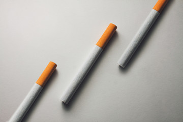 close-up of three cigarettes on a white surface
