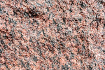 Abstract background. Close-up view of natural rought untreated grey granite texture.