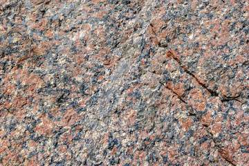 Abstract background. Close-up view of natural rought untreated grey granite texture.