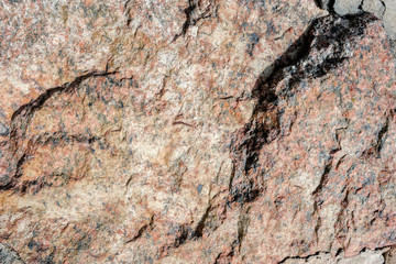 Abstract background. Close-up view of natural rought untreated grey granite texture.
